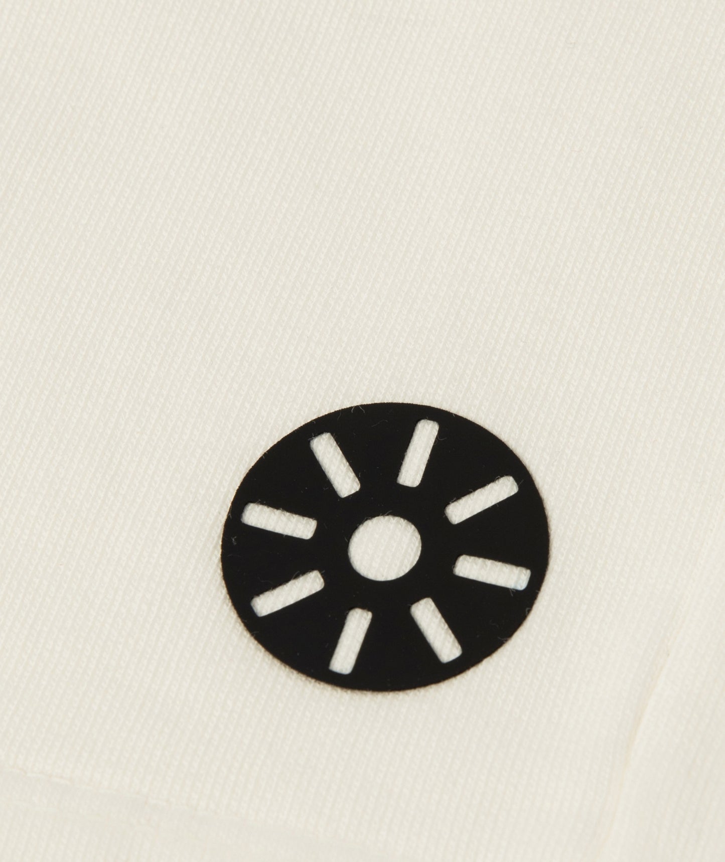 Close-up of Goldencubs white cotton girls shorts showing smooth fabric texture and black circular logo patch — premium kids athleisurewear detail.