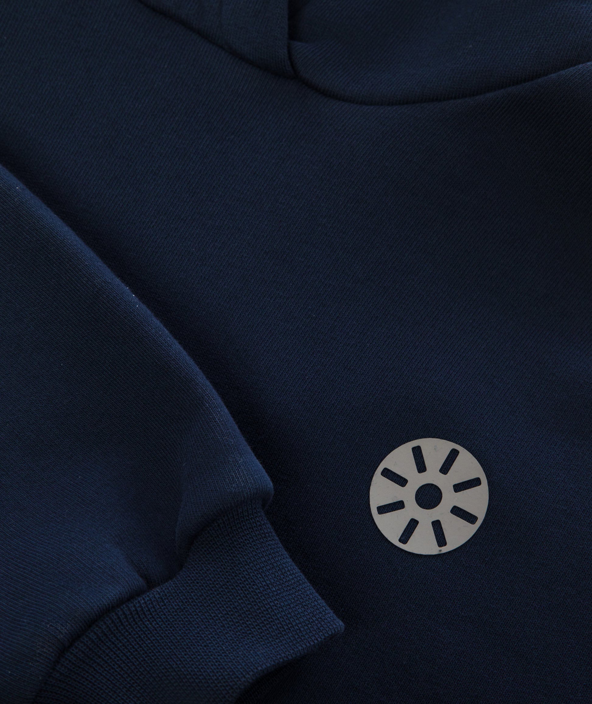 Close-up of Goldencubs gray circular logo printed on soft navy cotton hoodie fabric.