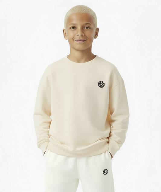 Front view of boy wearing Goldencubs cream cotton sweatshirt paired with white sweatpants — cozy and minimalist kids athleisure outfit.