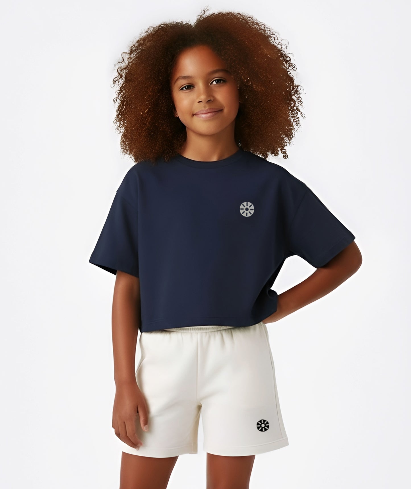 Girl in navy cropped Goldencubs T-shirt featuring short sleeves and minimalist logo detail, styled for a sporty look.