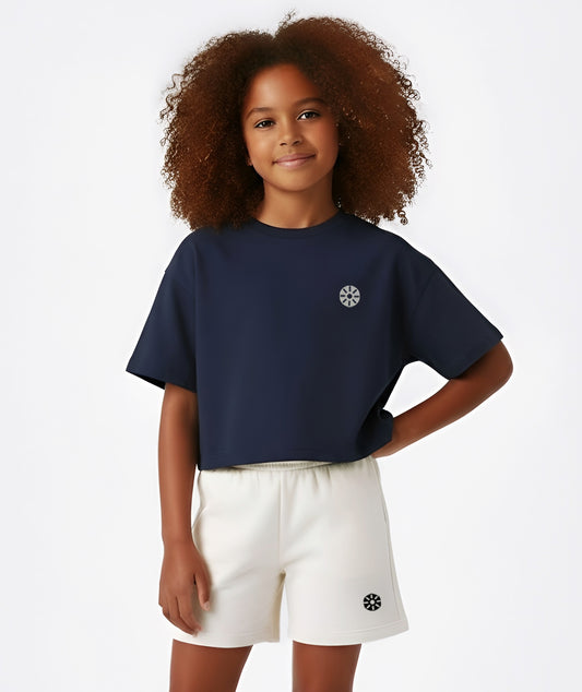 Girl in navy cropped Goldencubs T-shirt featuring short sleeves and minimalist logo detail, styled for a sporty look.