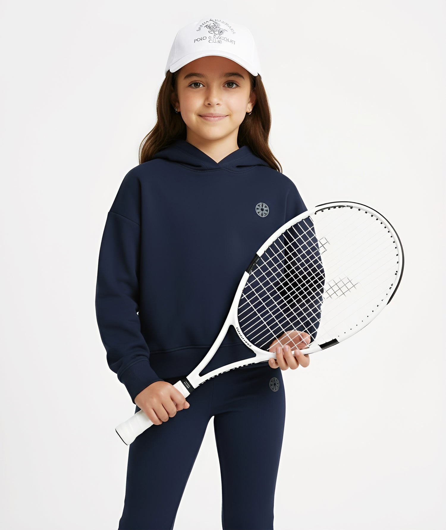Girl holding a tennis racket while wearing Goldencubs navy cotton hoodie and matching pants, styled in a sporty look.