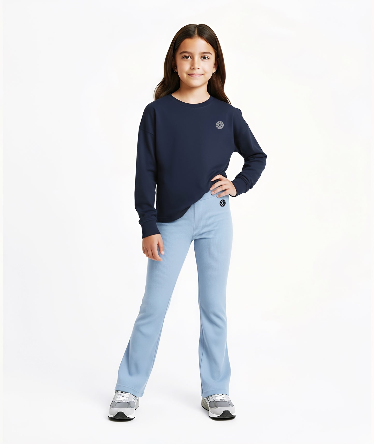 Girl wearing Goldencubs navy cotton long sleeve T-shirt with gray logo, paired with light blue flared pants and gray sneakers.