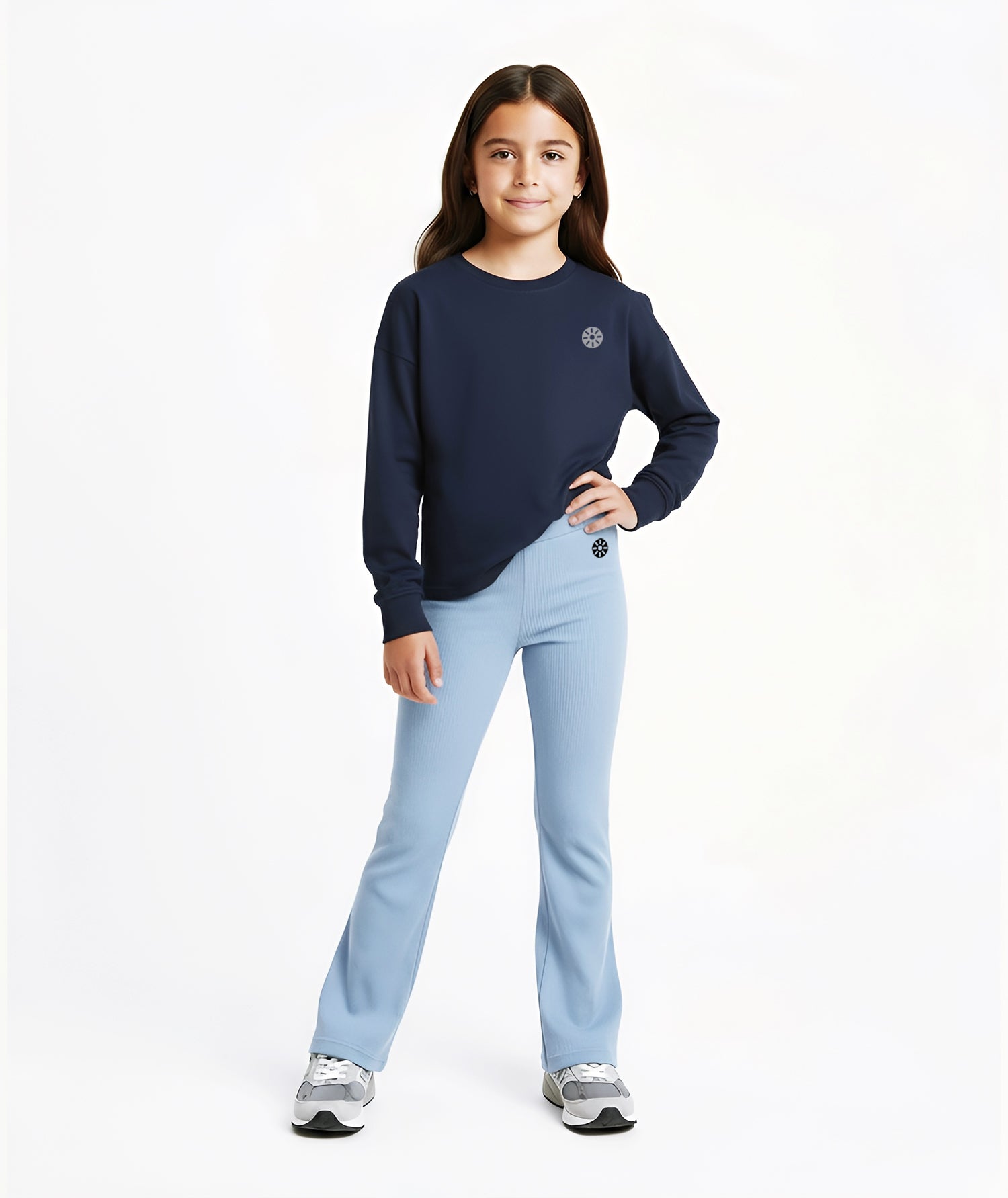 Girl wearing Goldencubs navy cotton long sleeve T-shirt with gray logo, paired with light blue flared pants and gray sneakers.
