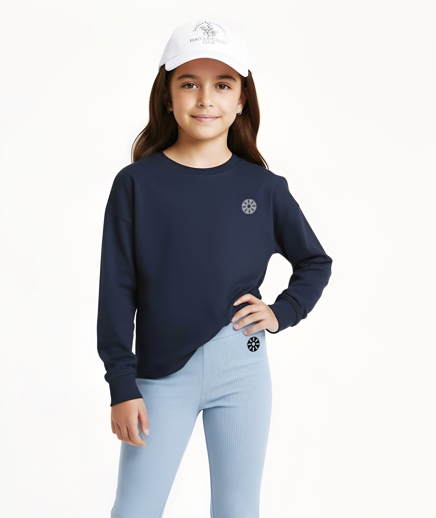 Girl wearing Goldencubs navy cotton long sleeve T-shirt and light blue flared pants with white cap, styled for sporty casual wear.