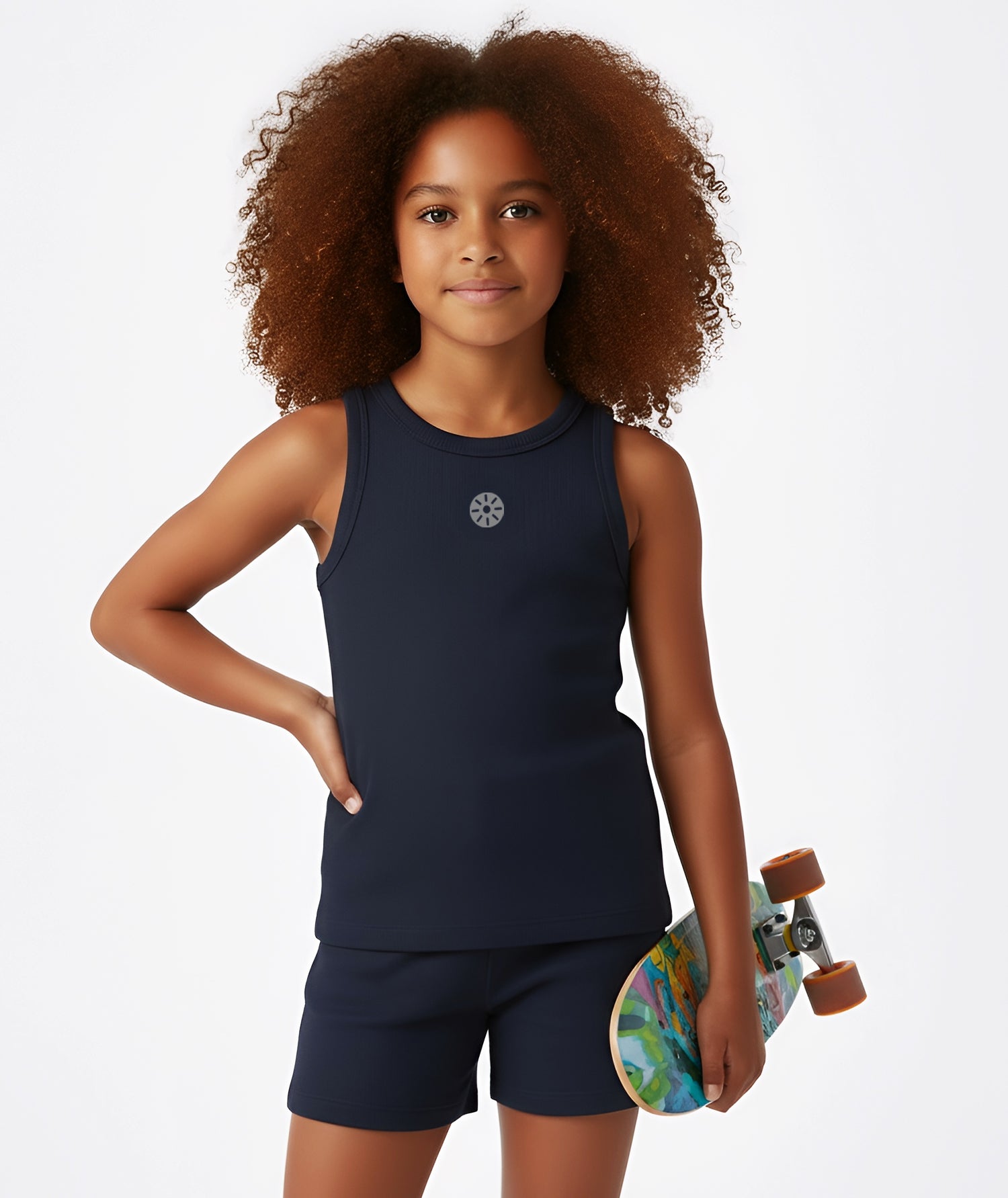 Girl holding a colorful skateboard while wearing Goldencubs navy cotton tank top and shorts, styled in a sporty casual look.