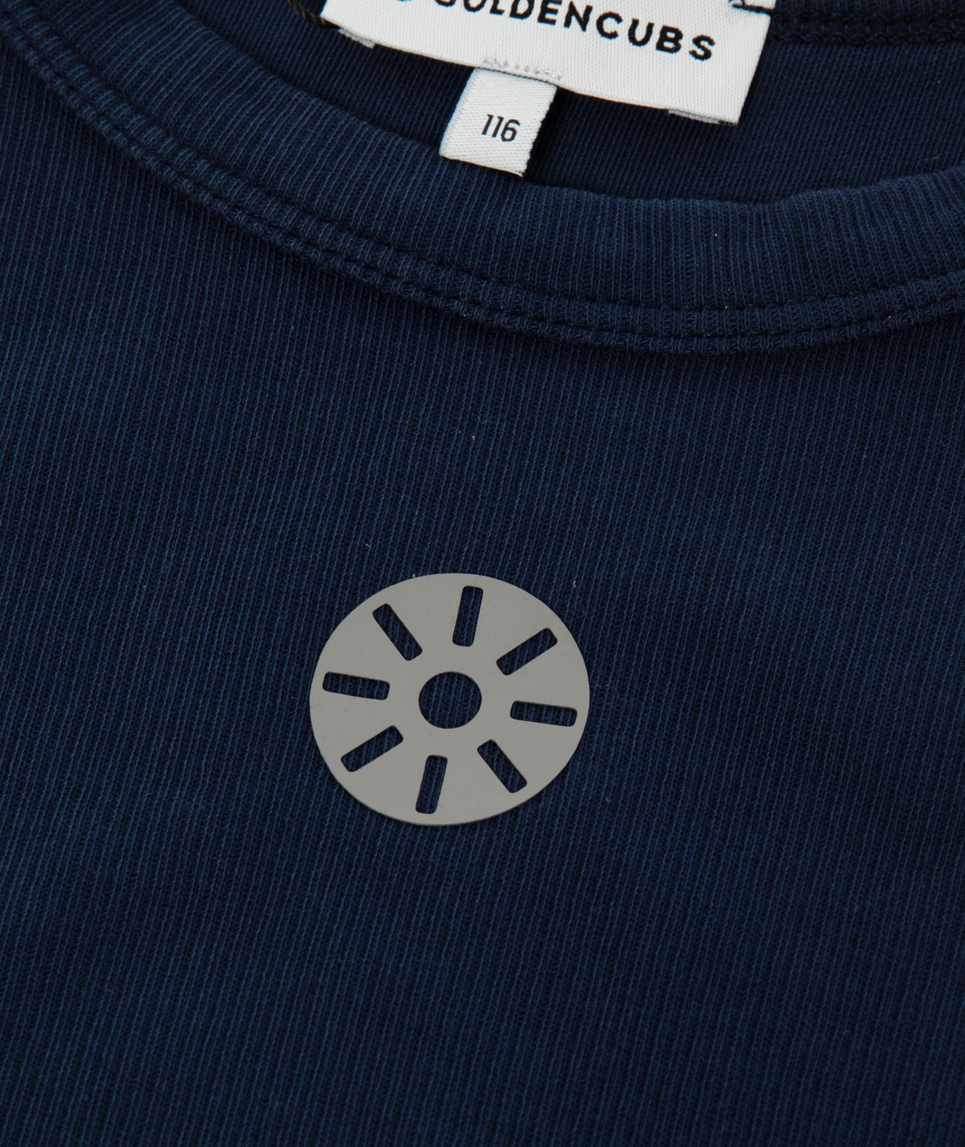 Close-up of Goldencubs gray circular logo printed on ribbed navy cotton tank top fabric.