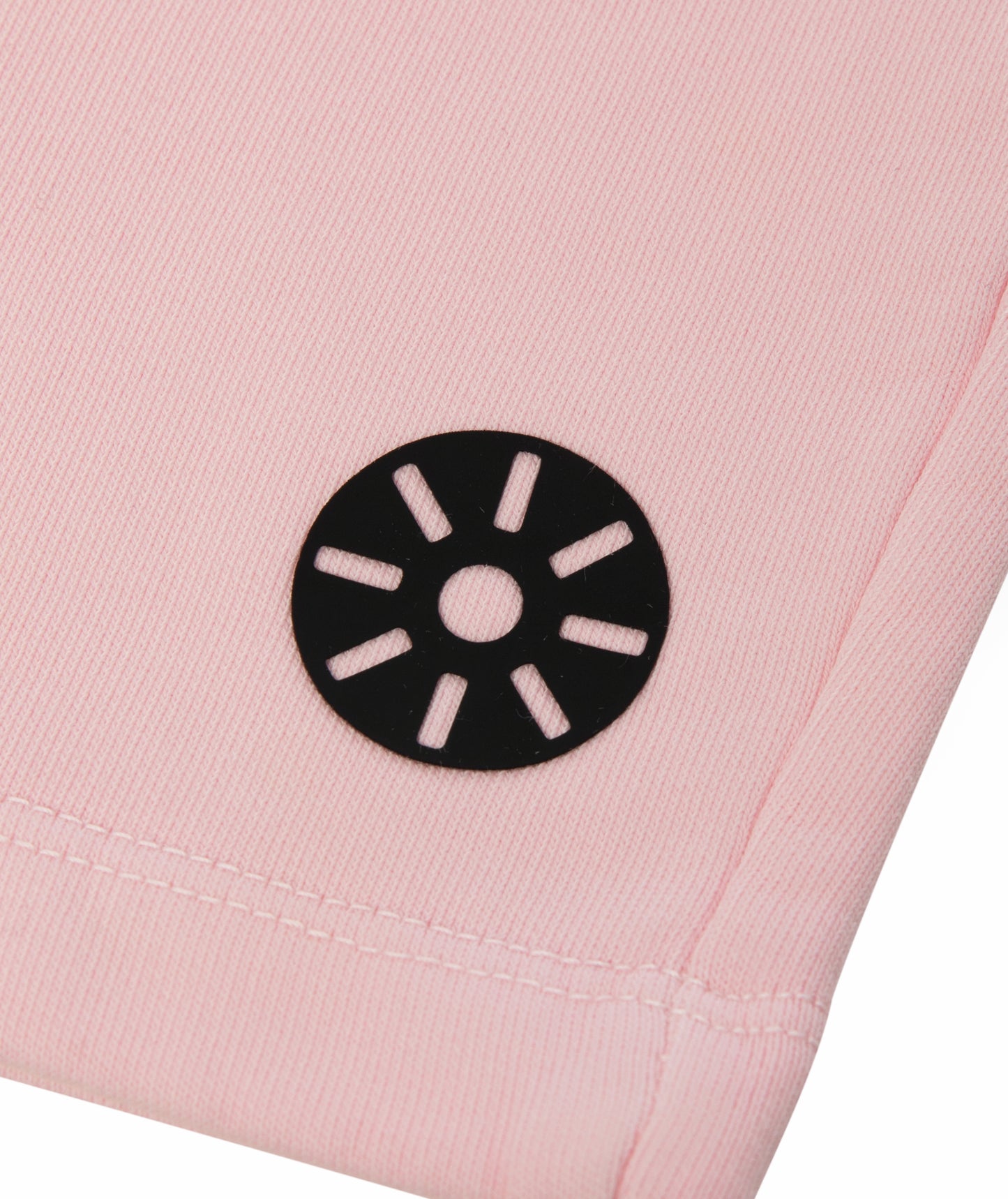 Close-up of Goldencubs black circular logo printed on soft pink cotton fabric of the shorts.