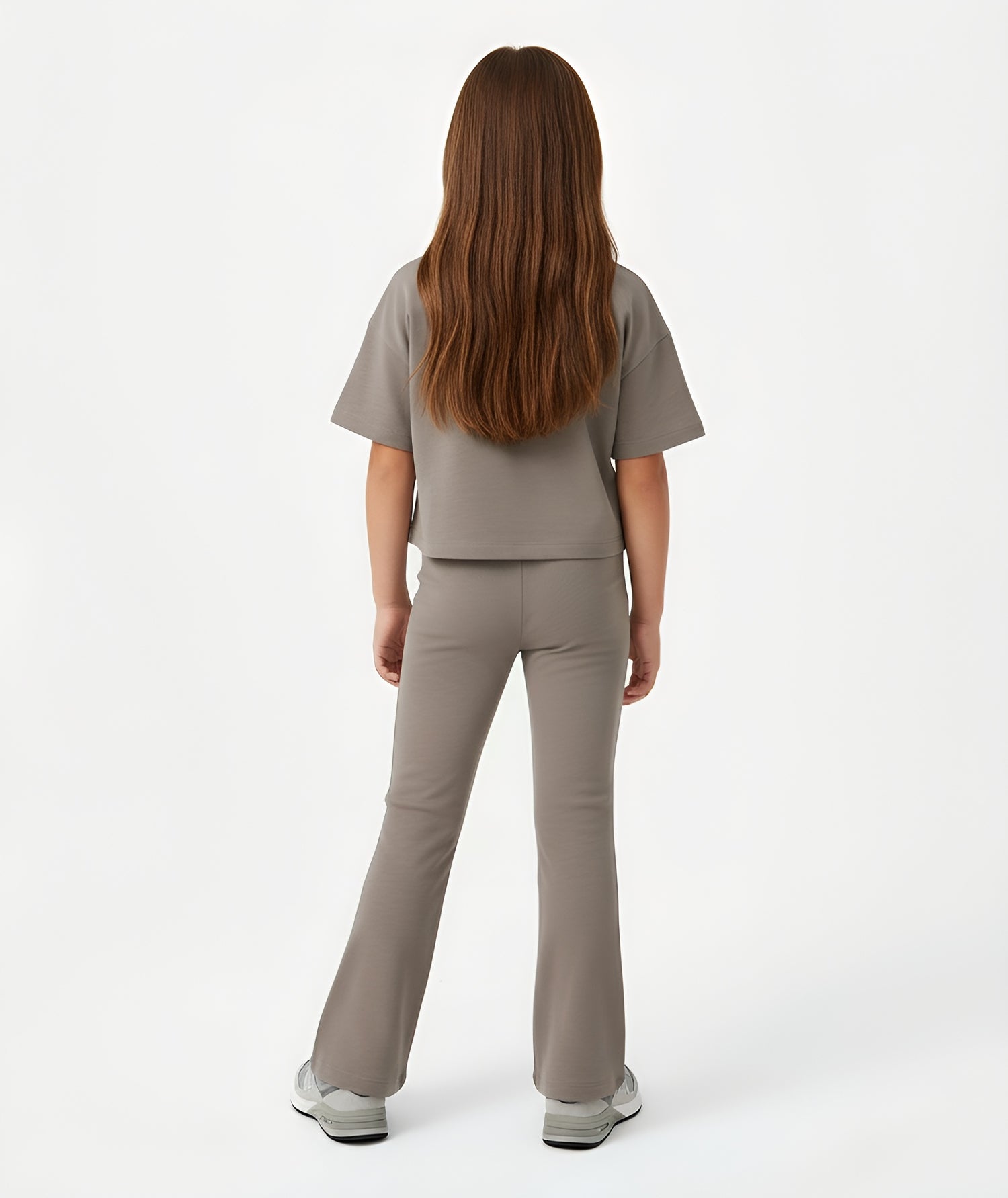 Back view of girl wearing Goldencubs taupe cotton flared pants, showing comfortable stretch fit and smooth silhouette.