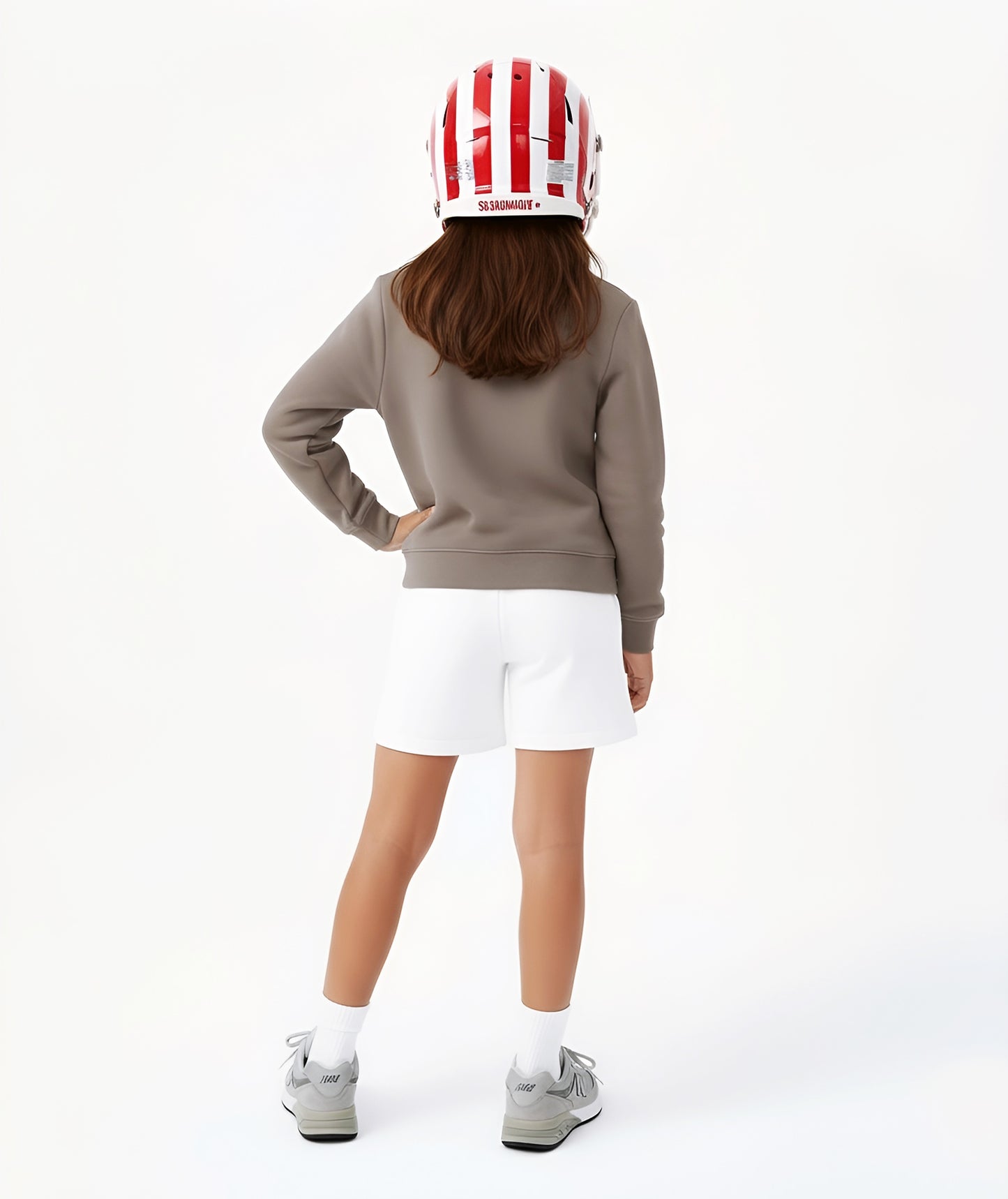 Back view of girl wearing Goldencubs taupe cotton sweatshirt, showing relaxed fit and ribbed hem detail.