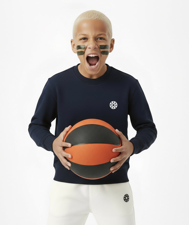 Smiling boy holding a basketball while wearing Goldencubs navy cotton long sleeve T-shirt — sporty and playful premium kidswear look.