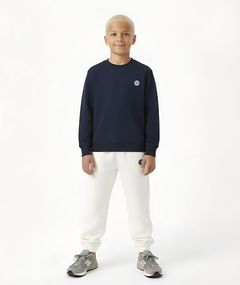 Front view of boy wearing Goldencubs navy cotton long sleeve T-shirt paired with white sweatpants — stylish and comfortable everyday kids outfit.