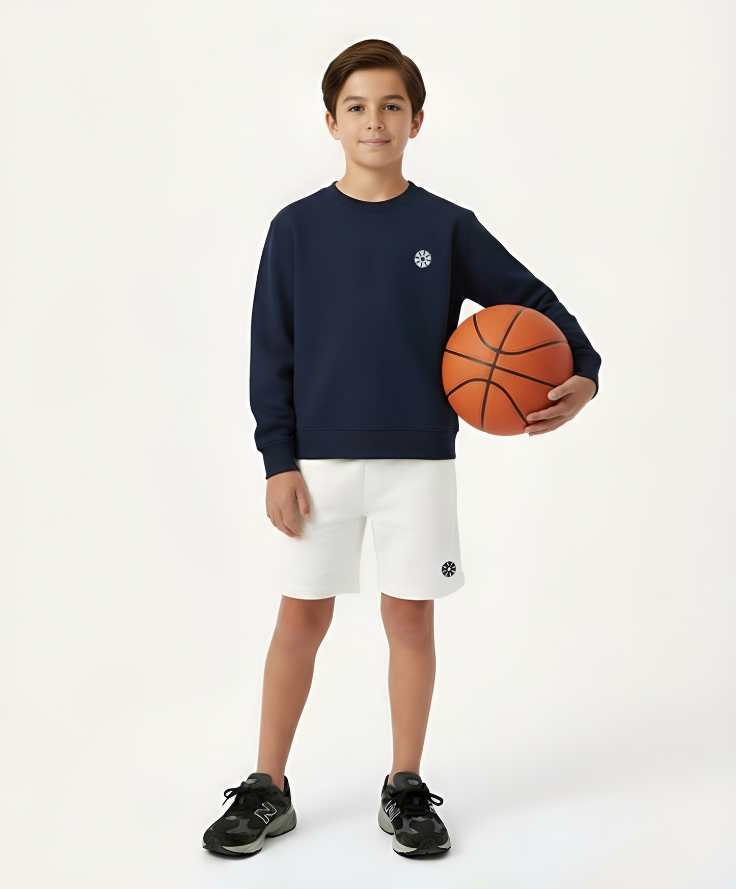 Front view of boy wearing Goldencubs navy cotton boys sweatshirt and white shorts while holding a basketball — stylish and comfortable kids athleisure outfit.