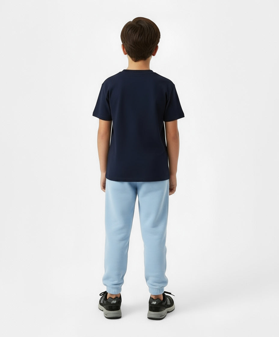 Back view of boy wearing Goldencubs navy cotton T-shirt paired with light blue sweatpants — classic and comfortable kids athleisure look.