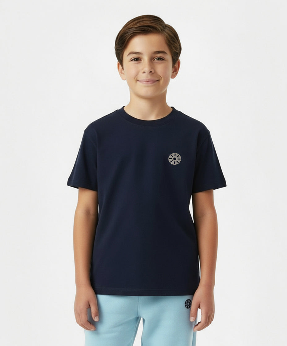 Close-up of boy wearing Goldencubs navy cotton T-shirt with black circular logo patch — premium cotton kids T-shirt for casual and sporty occasions.