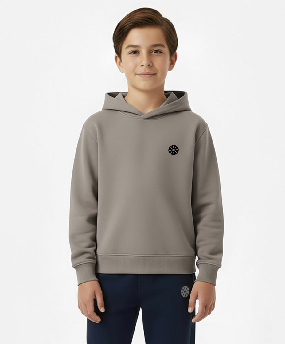 Close-up of boy wearing Goldencubs taupe cotton hoodie featuring circular black logo patch — cozy and stylish everyday sweatshirt.