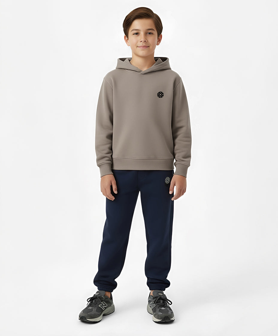 Front view of Goldencubs taupe cotton boys hoodie paired with navy sweatpants — soft and minimalist kids athleisure look with signature logo patch.