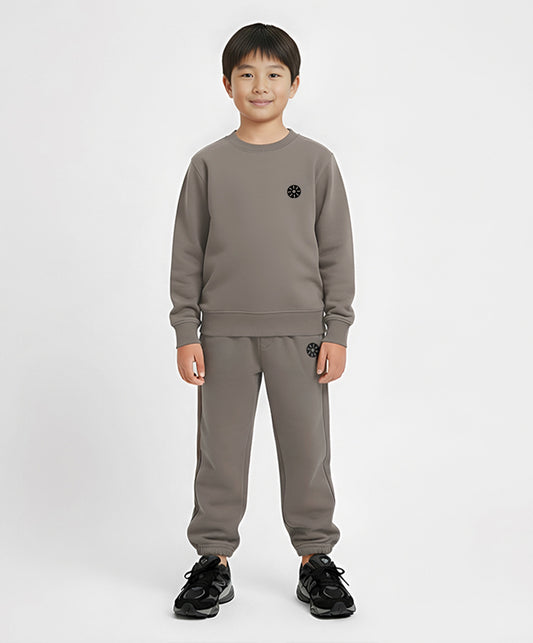 Front view of boy wearing Goldencubs taupe cotton sweatpants and matching sweatshirt — comfortable and stylish everyday outfit.