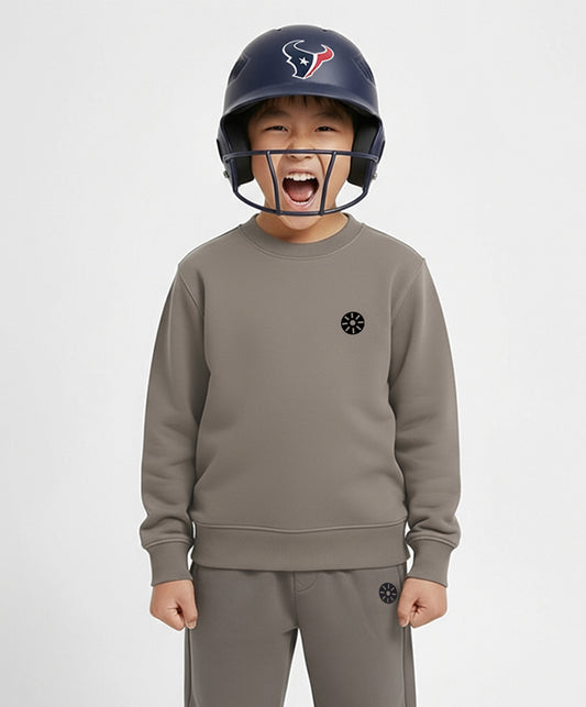 Boy wearing Goldencubs taupe cotton sweatshirt and helmet, smiling confidently — stylish and durable kids sportswear with premium comfort.