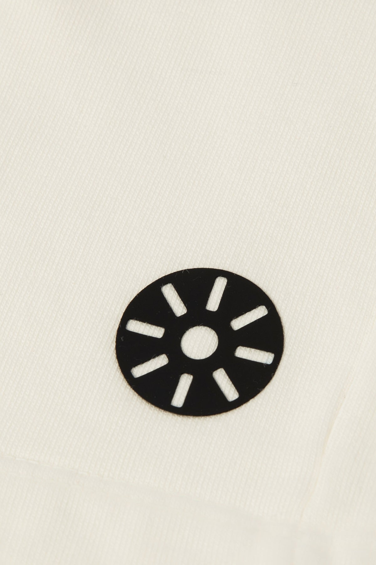 Close-up of Goldencubs white cotton boys shorts showing ribbed texture and circular black logo patch — premium quality and fine stitching details.