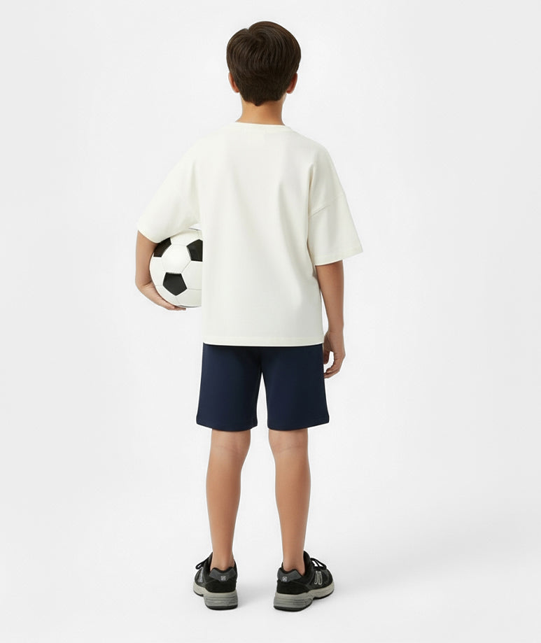 Back view of boy wearing Goldencubs white cotton t-shirt with navy shorts — sporty and breathable outfit for boys.