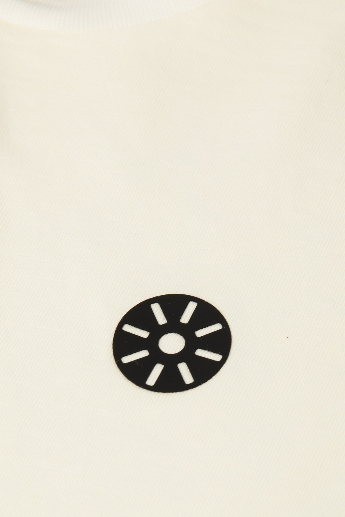 Close-up of Goldencubs white cotton boys t-shirt showing soft jersey fabric and black circular logo — minimal and premium kidswear detail.