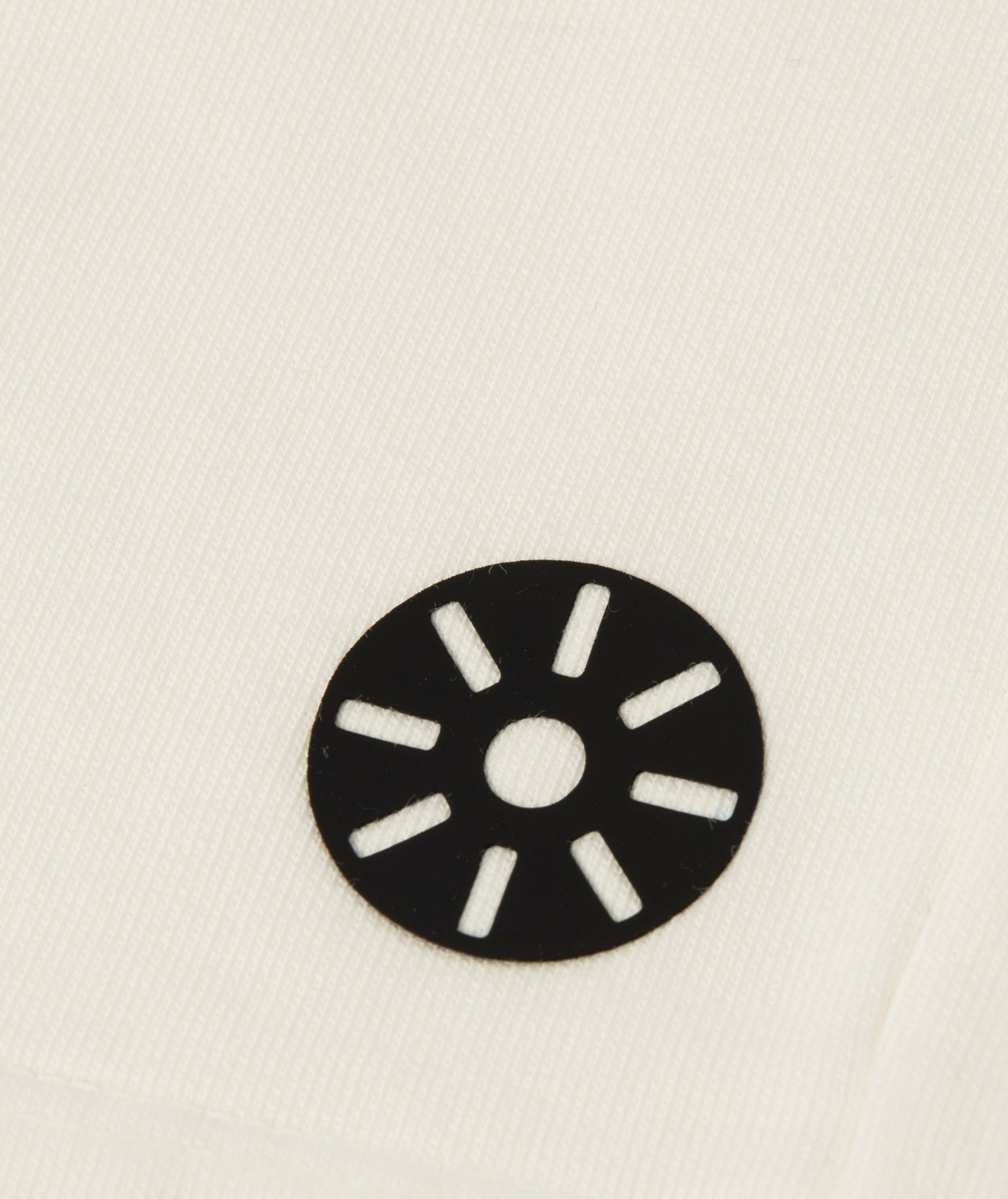 Close-up of Goldencubs white cotton girls shorts showing smooth fabric texture and black circular logo patch — premium kids athleisurewear detail.