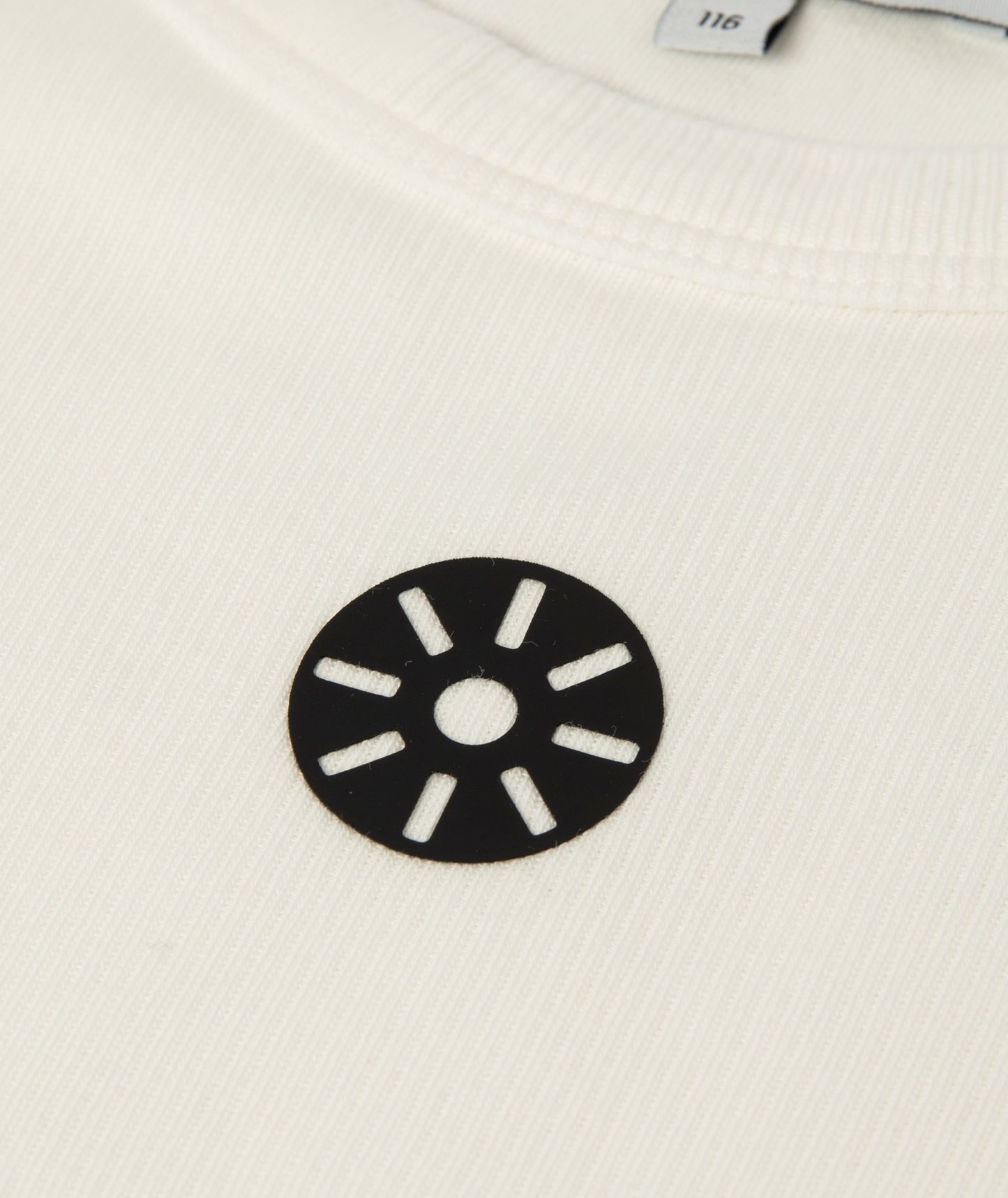 Close-up of Goldencubs white ribbed cotton girls tank top showing fabric texture and circular black logo patch detail.