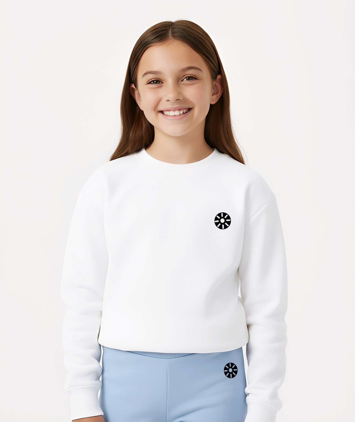 A girl wearing a white cotton sweatshirt with the Goldencubs logo, styled with light blue joggers for a clean and modern athleisure look perfect for school days or weekend outings.