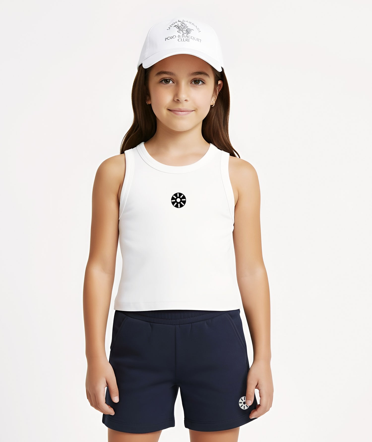 A girl in a white cotton tank top styled with navy shorts and a white cap, representing a relaxed Goldencubs athleisure look for outdoor activities and summer comfort.